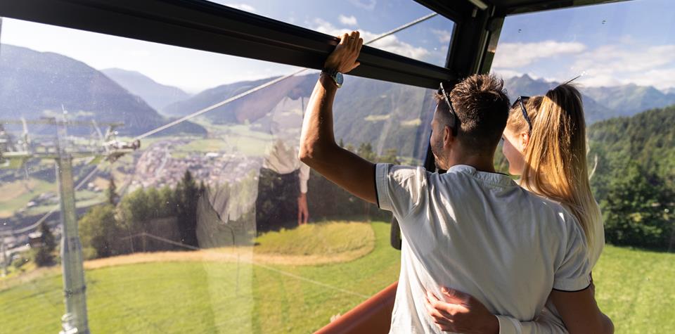 A couple looks out from a cable car