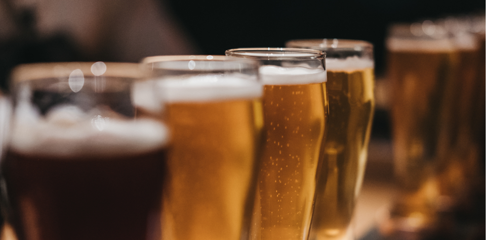 Diversi bicchieri di birra sono su un tavolo di legno
