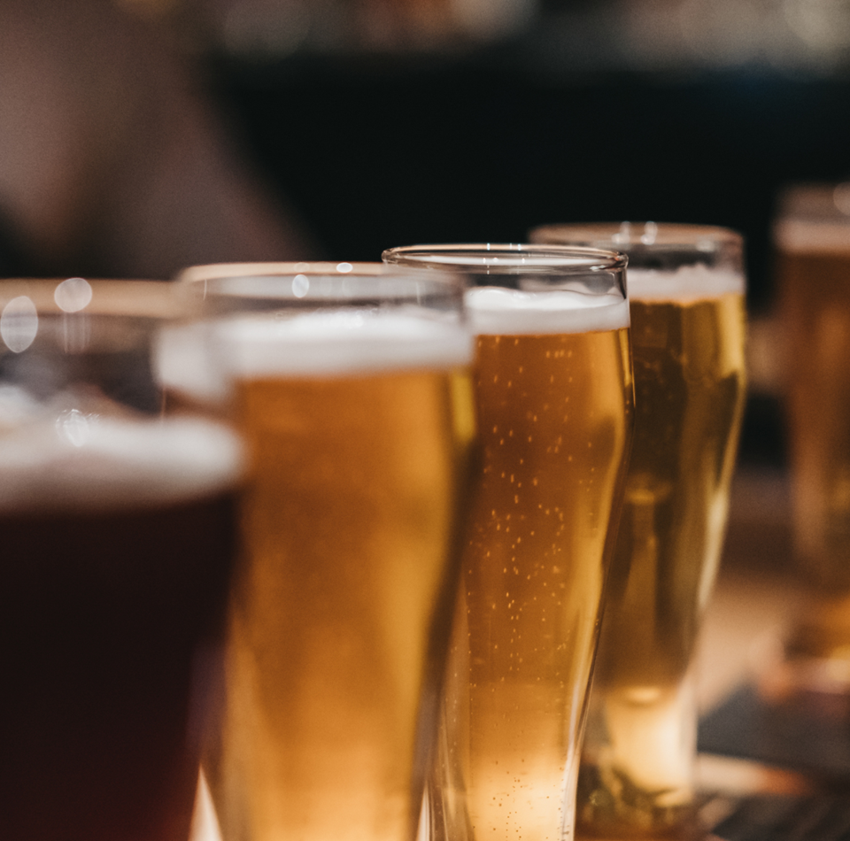 Diversi bicchieri di birra sono su un tavolo di legno