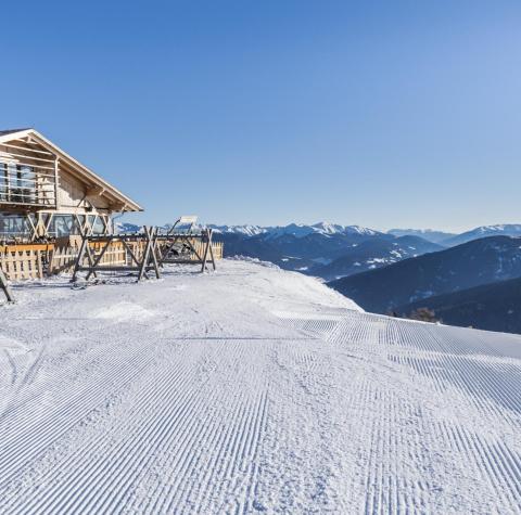 A ski slope with a mountain hut beside it