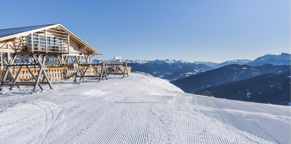 A ski slope with a mountain hut beside it