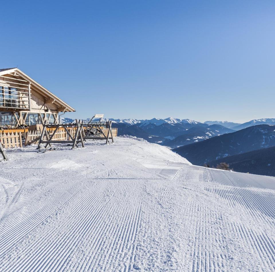 A ski slope with a mountain hut beside it