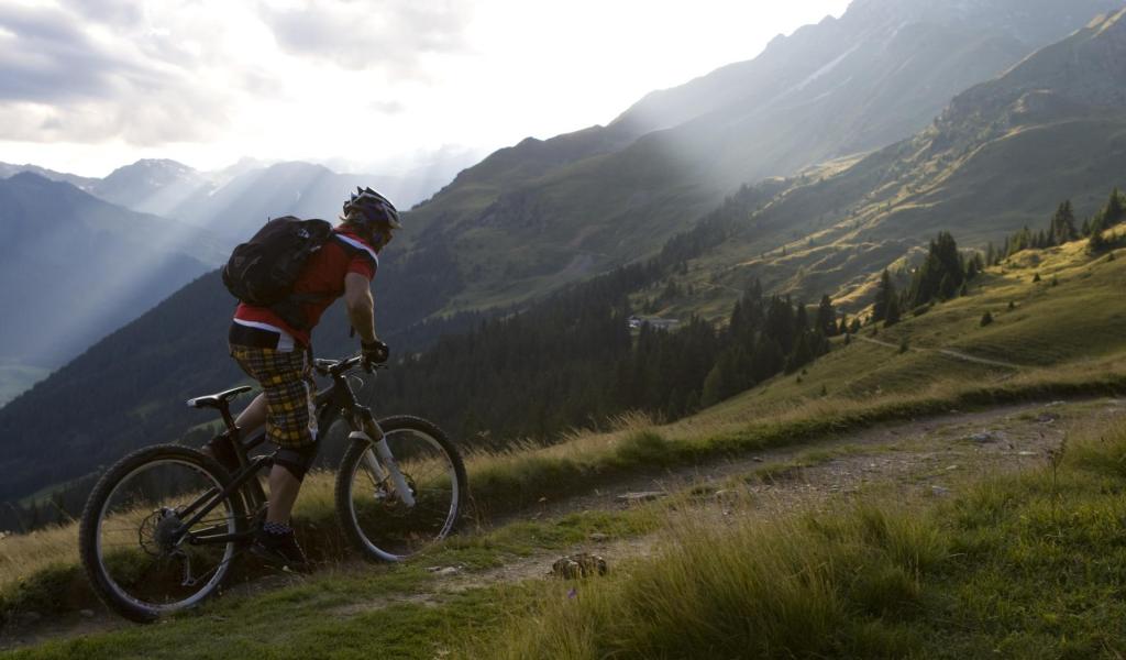 Ein Mann mit seinem Fahrrad auf einer Downhill Strecke
