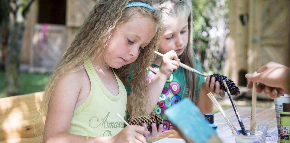 Due bambini dipingono con i colori acrilici
