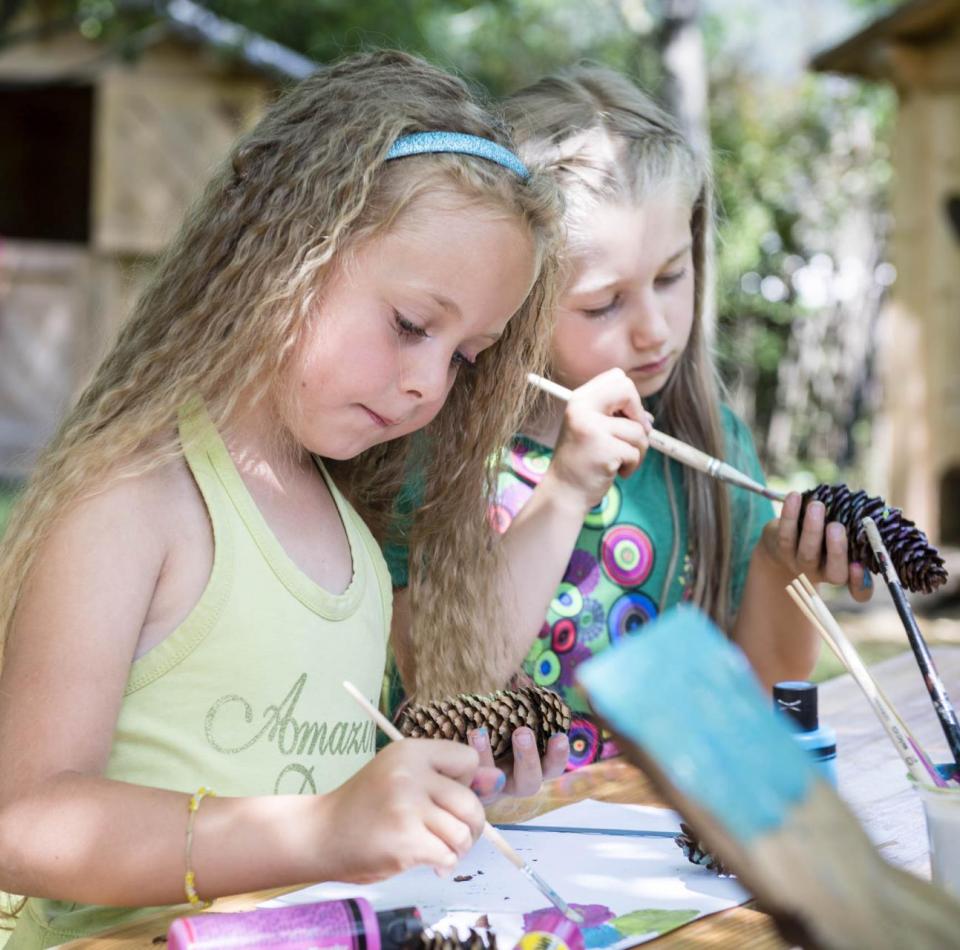 Due bambini dipingono con i colori acrilici