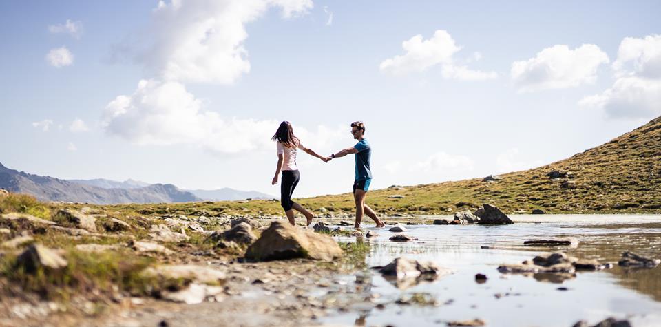 una coppia al Passo di Pennes presso un lago di montagna