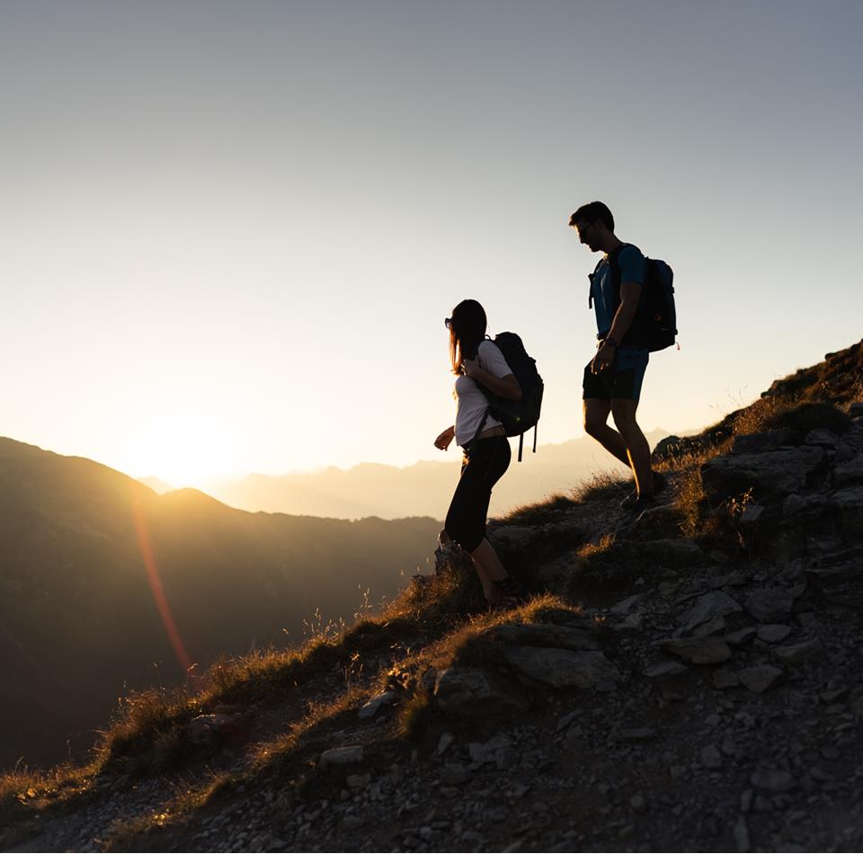 un uomo e una donna al Passo di Pennes all’alba