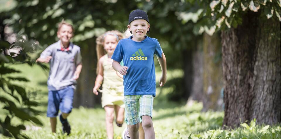 Drei Kinder spielen im Garten