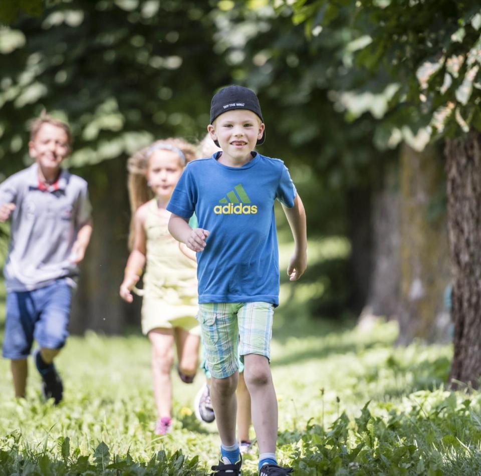 Tre bambini giocano in giardino