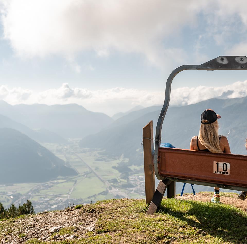 two female hikers sitting on a bench and enjoying the view