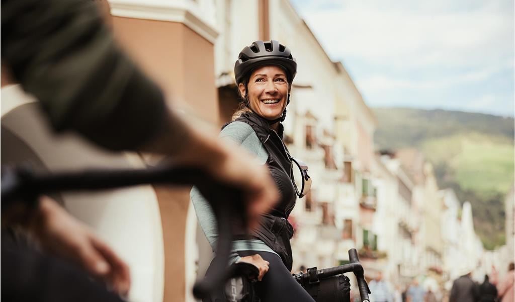 A man and a woman are sitting on their bicycles in the city of Sterzing