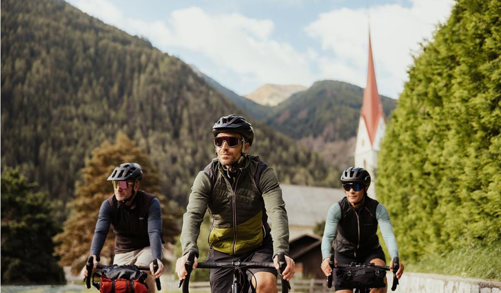 Three people are riding bicycles