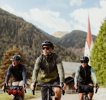 Three people are riding bicycles