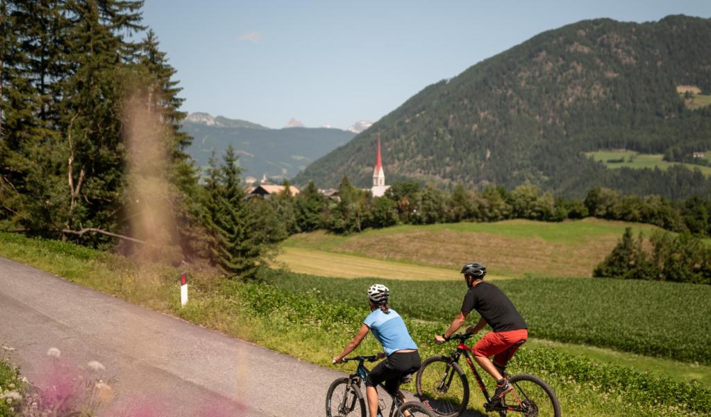 Ein Mann und eine Frau mit Fahrrädern auf einem Fahrradweg