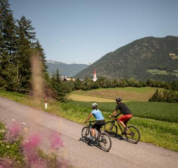 Un uomo e una donna con le biciclette su una pista ciclabile