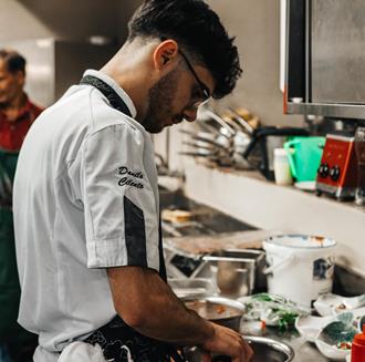 Un cuoco prepara un piatto