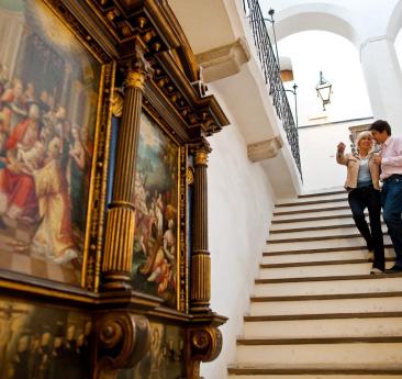 Ein Frau und ein Mann stehen auf einer Treppe in einem historischen Gebäude