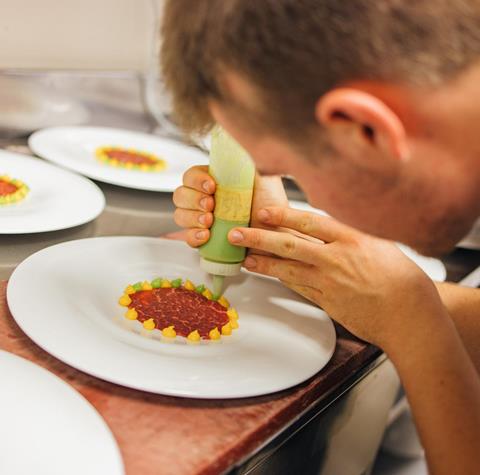 A chef is preparing an appetizer creation