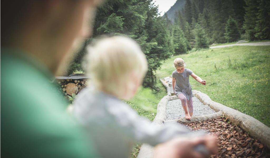 a child walks along a barefoot path