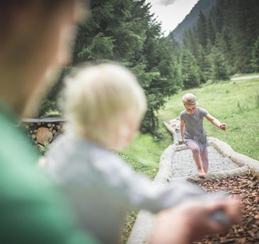 Kind läuft einen Barfußweg