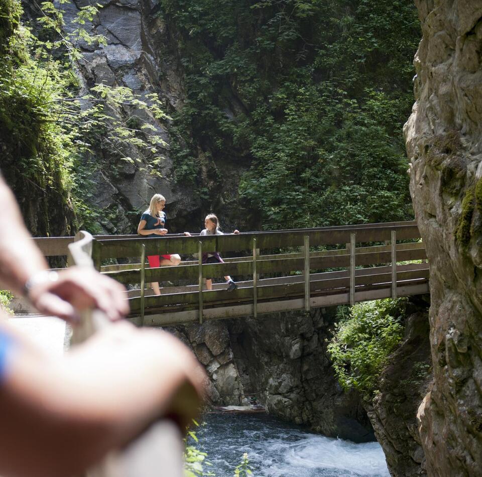 A woman and a child are standing on a bridge