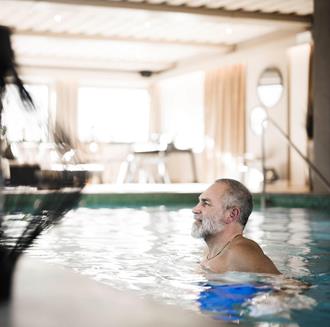 Un uomo nuota in piscina