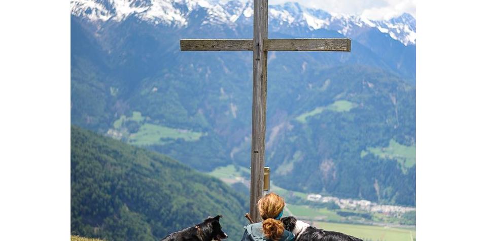 Frau mit Hunden am Gipfelkreuz