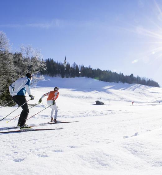 A man and a woman cross-country skiing