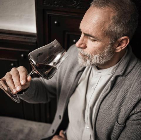 Un uomo beve un bicchiere di vino rosso