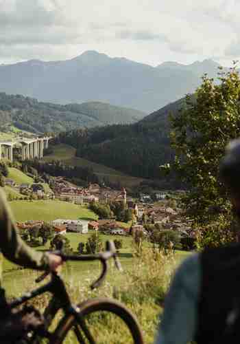 Two cyclists are looking at the city of Sterzing